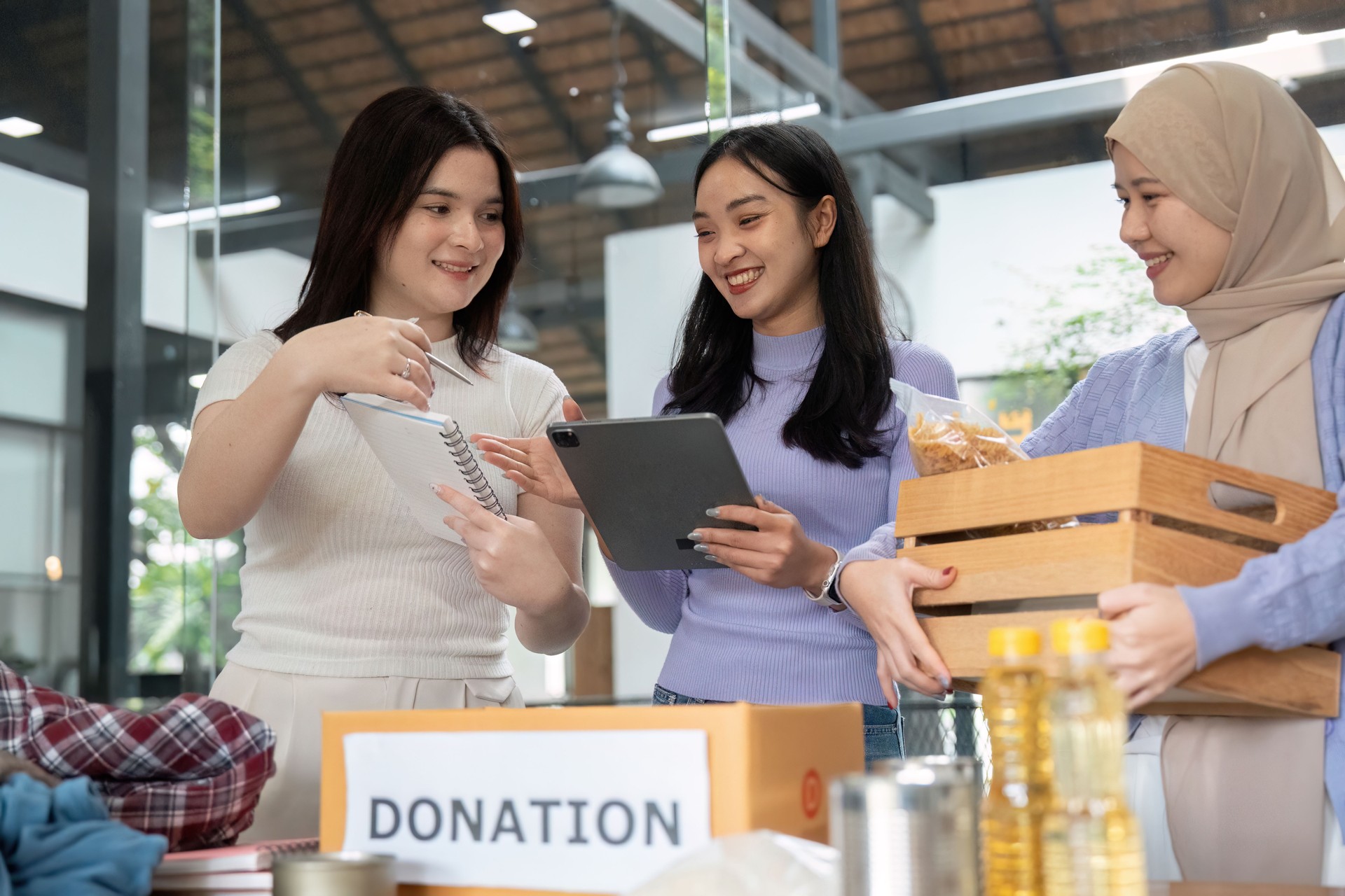 Sustainability and Community Engagement. Volunteers discussing donation logistics while preparing items for distribution.